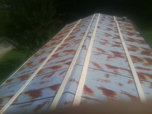 Rusted metal roof panels with new wood purlins before replacement — Storm Damage Roof Repair in Sutherlin by Roofing Brothers