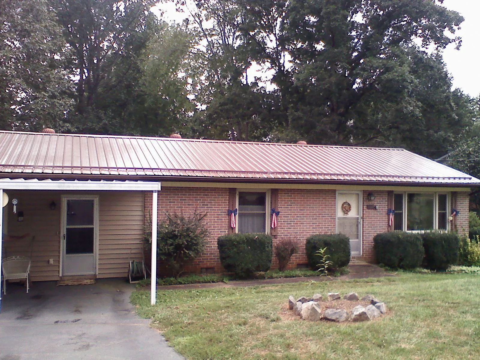 Bronze metal roof and carport on a brick ranch home — Roof Repair work by our crew in Sutherlin